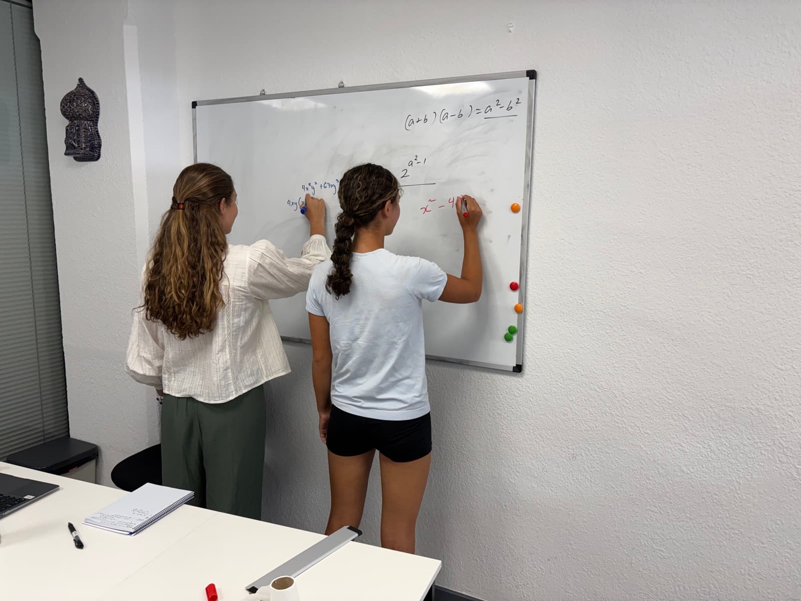 Students working side by side through factorisation in a small group.